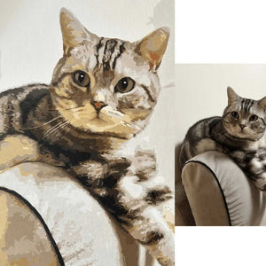 Two images of a tabby cat sitting on a couch, first being a paint by numbers painting and second a photo of the same cat.