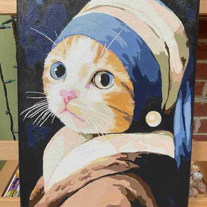 Cat wearing a pearl earring with a blue headband on a dark background