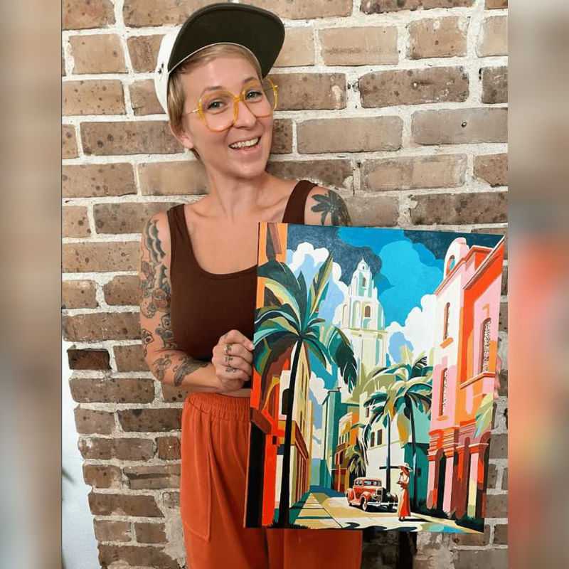 A lady standing with a beautiful abstract paint by numbers painting.