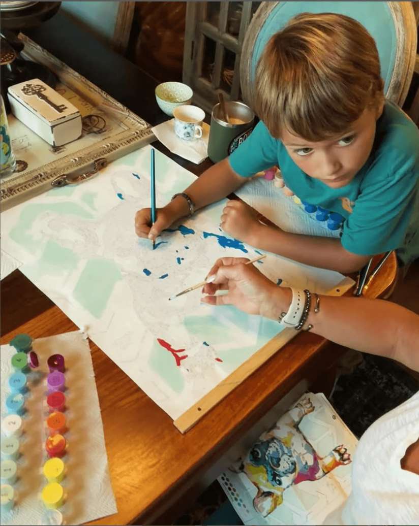 Kid having fun time painting a paint by numbers canvas in Canada