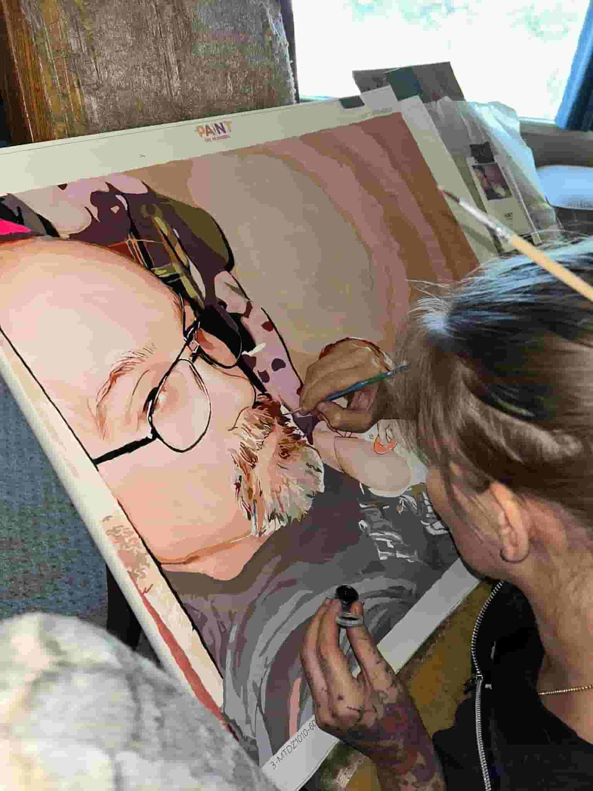 Custom paint by numbers canvas showing a man with glasses holding a sleeping baby, a personalized artwork created from a customer photo.