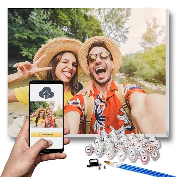 Custom Paint By Numbers Candada of a happy couple taking an outdoor selfie, turned into a personalized painting with paint pots, brushes, and phone upload interface