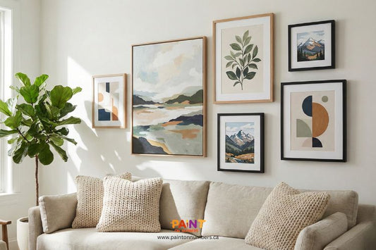 Styled living room with a neutral sofa, houseplant, and a curated gallery wall featuring framed landscape and abstract artwork.