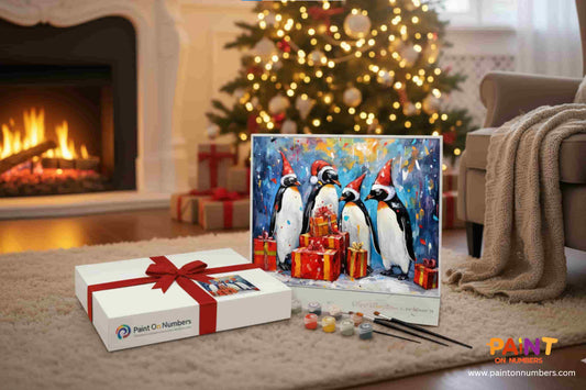 Christmas Paint by Numbers kit featuring a festive penguin painting with Santa hats and presents, displayed by a fireplace and Christmas tree, perfect holiday gift idea from Paint On Numbers.