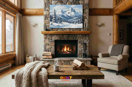 Winter mountain paint by numbers artwork hanging above a stone fireplace in a warm, rustic living room.