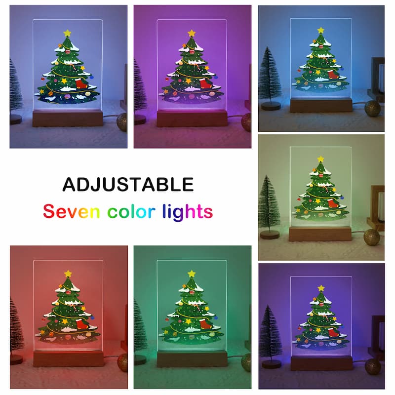 A collage showing a small illuminated Christmas tree display in seven different color light modes, with the text 'ADJUSTABLE Seven color lights' in the center. The tree sits on a wooden base inside a clear rectangular box, with small decorative trees and ornaments around it.
