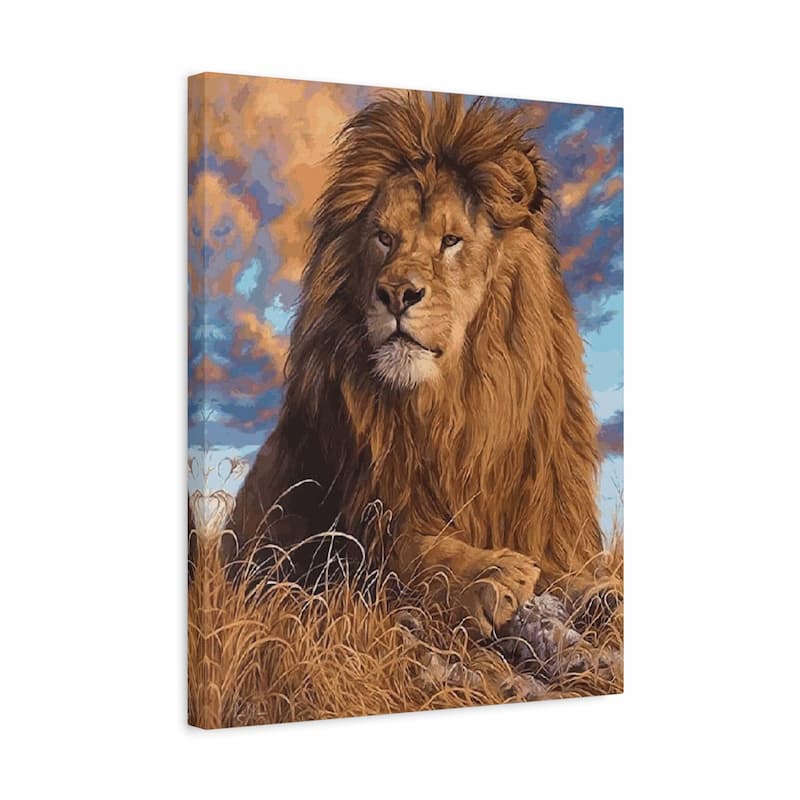 A square canvas wall art print depicting a majestic lion resting in golden grass under a blue and orange sky, shown at a slight angle on a white background.