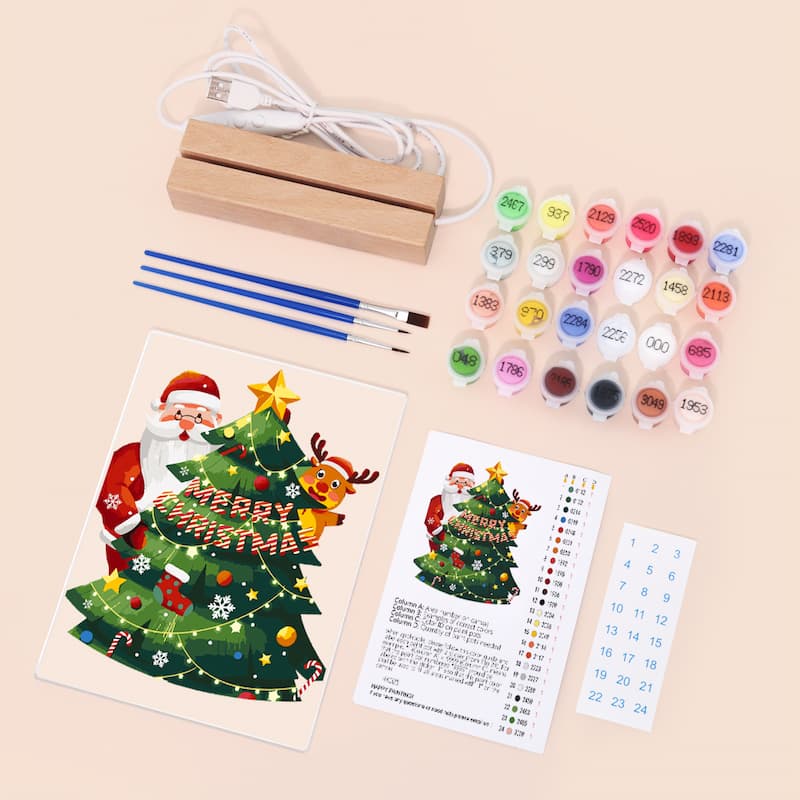 Christmas-themed art set with paint, brushes, and coloring book on a beige background