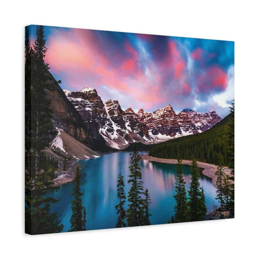 Sunrise at Lake Moraine Paint By Numbers painting featuring vibrant pink and blue sky over snow-covered Rocky Mountains, turquoise lake, and lush pine forest in Alberta, Canada shown in a frame