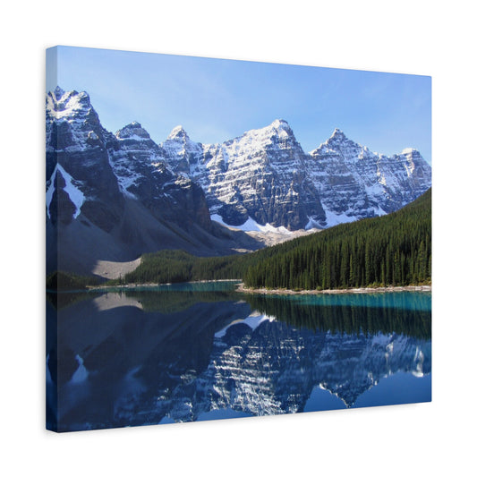 Moraine Lake Paint By Numbers painting featuring crystal-clear turquoise waters, towering snow-covered peaks of the Canadian Rockies, and a dense pine forest reflecting perfectly in the still lake shon in a frame
