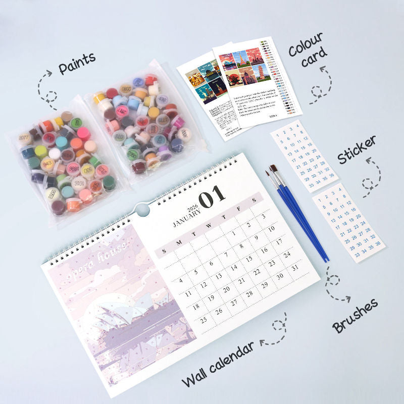 Flat lay of a paint by numbers calendar kit showing labeled components including paint pots, color card, stickers, brushes, and the spiral-bound wall calendar.