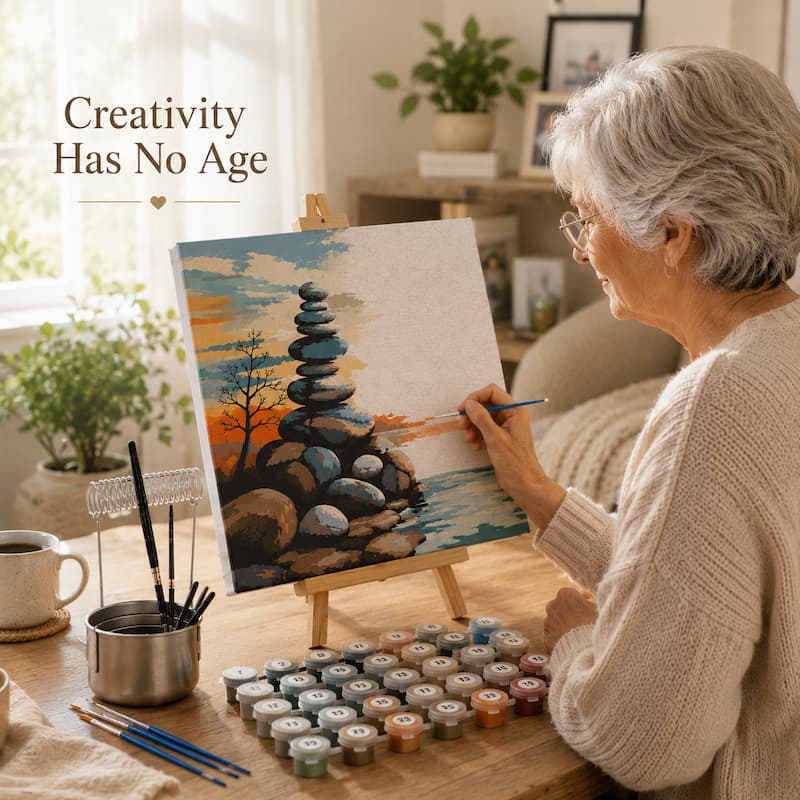 Senior woman peacefully painting a framed paint by numbers canvas on a wooden tabletop easel with paint pots, brushes, and brush cleaner combo in a cozy home setting.