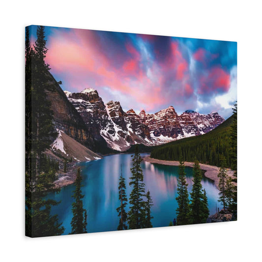 Sunrise at Lake Moraine Paint By Numbers painting featuring vibrant pink and blue sky over snow-covered Rocky Mountains, turquoise lake, and lush pine forest in Alberta, Canada shown in a frame
